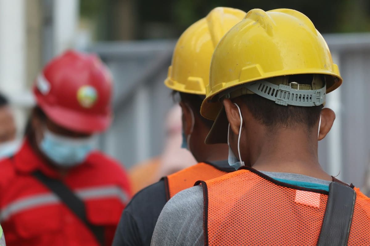 Trabajadores con cascos y chalecos en una obra