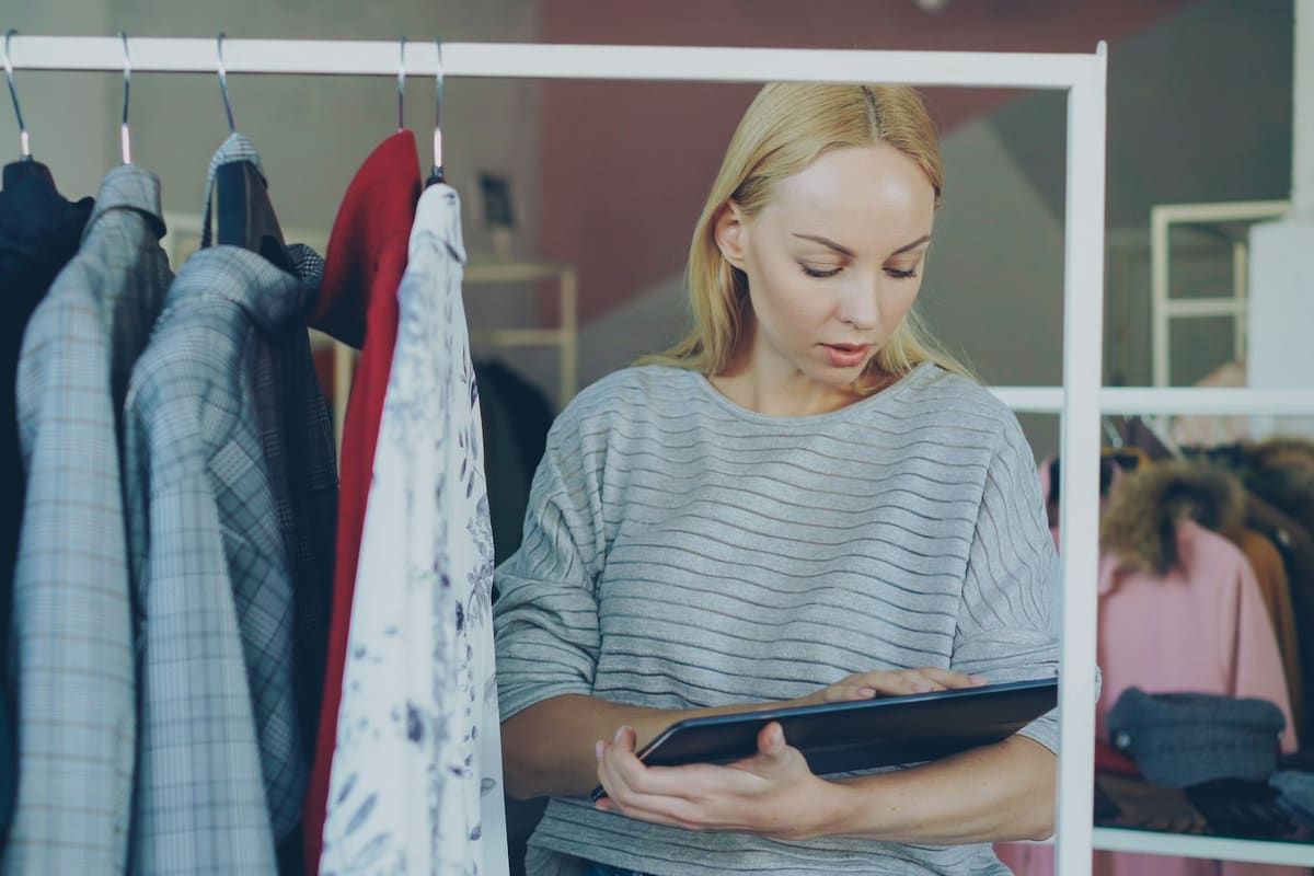 Comerciante revisando el stock de su tienda de ropa